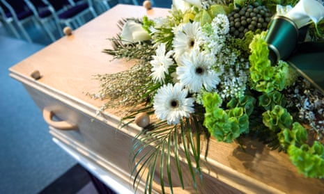 A coffin with a flower arrangement at a funeral
