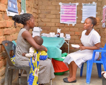 A young mother and child in Malawi with a nurse