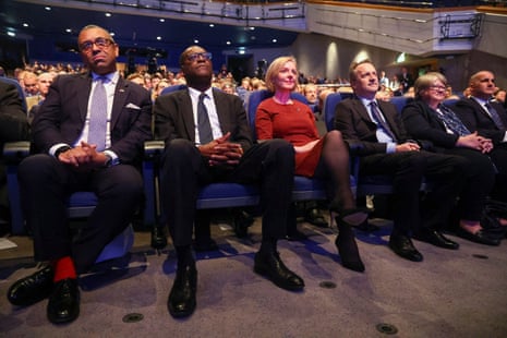 Liz Truss with her husband and cabinet colleagues sitting in the hall at the Tory conference opens in Birmingham.