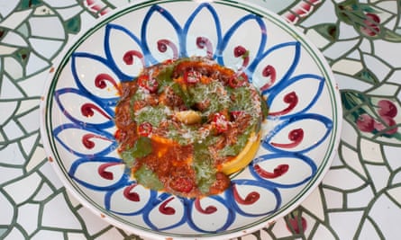Pasta con polenta y estofado de cordero, en un plato decorativo sobre una mesa decorativa.