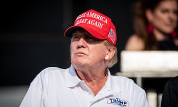 White man wearing white polo and red hat