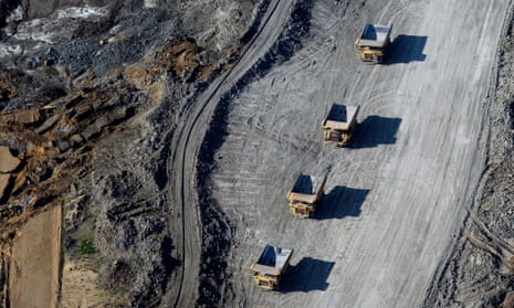 An aerial view of four vehicles in a barren mining landscape