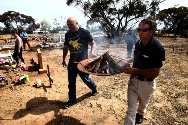 Jason Kelly (left) takes the ceremonial fire to the site of the ceremony.