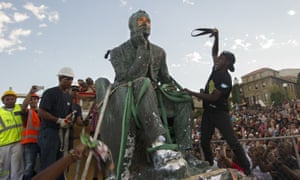 Students attack the defaced University of Cape Town statue of Cecil Rhodes as it is removed after a month of student demonstrations.