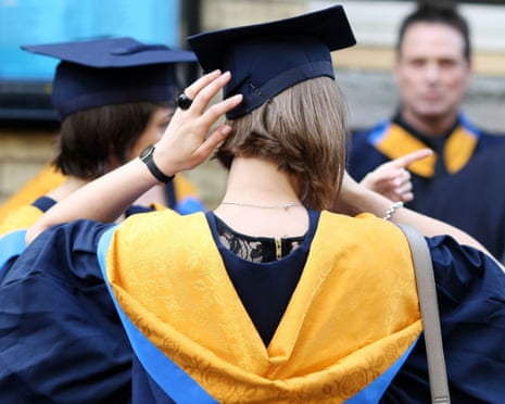 Female student pictured from behind in graduation gown and graduate cap