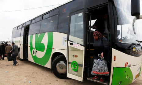 A woman disembarks a Palestinians-only bus before crossing through Israel’s Eyal checkpoint as she returns to the West Bank.