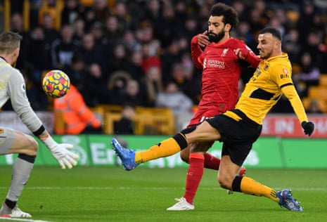 Wolverhampton Wanderers’ Moroccan midfielder Romain Saiss (R) fends off Liverpool’s Egyptian midfielder Mohamed Salah