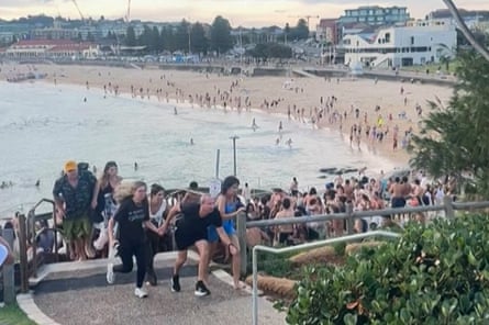 People running up steps from the beach