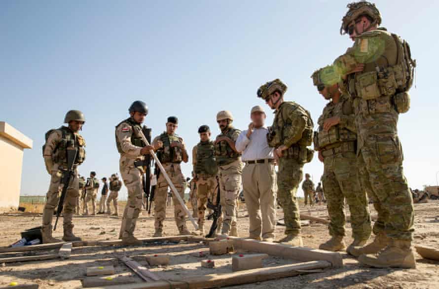 Australian army officers listen to a briefing delivered by an Iraqi army officer during urban warfare training at the Taji Military Complex in Iraq.