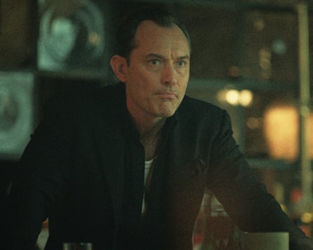 Jude Law playing Jake is standing looking pensive