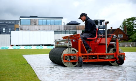 Groundstaff work to dry the field in Guildford.