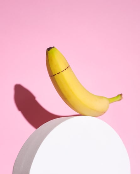 Photograph of a banana with a dotted cut line around the tip