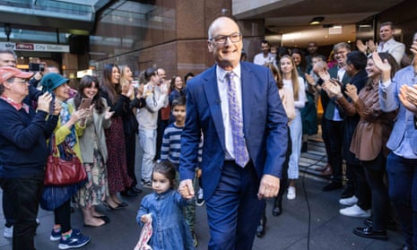 Koch surrounded by people applauding as he leaves Seven's studio in central Sydney