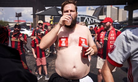 Jam Henson, a shirtless Atlanta United fan drinking beer.