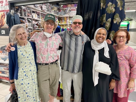 Three women and two men smile for a photograph