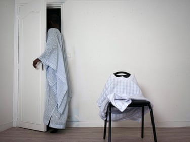 Worn light-blue lace bubu and striped white jam-puut, Grey Area, 2021A figure leaves the room while another seems to remain seated, formed only by a garment draped over a chair. Set within the domestic space, the image considers how patriarchal ideas of masculinity can turn withdrawal into a position of authority, while silence, care and vulnerability are left to be carried by those who remain