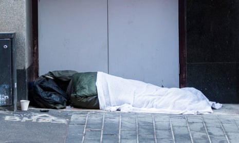 A homeless person sleeps in a shopfront in the centre of Birmingham.