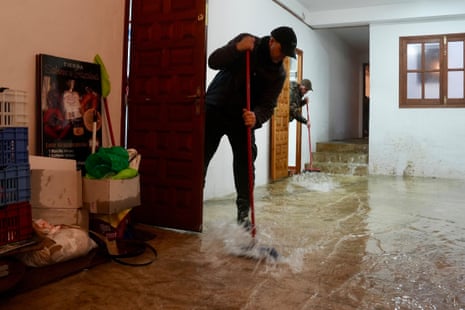 A man bails water out of his home