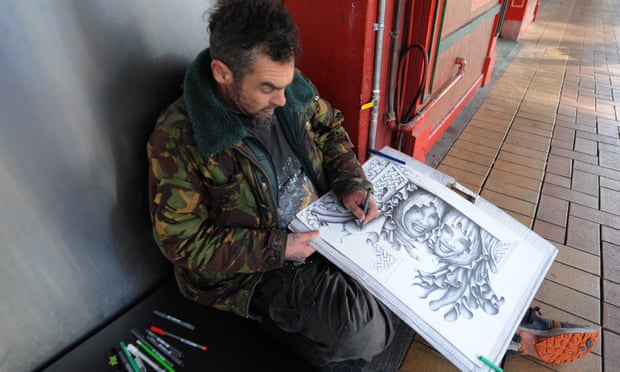 A homeless man draws a picture on a street in Wellington.