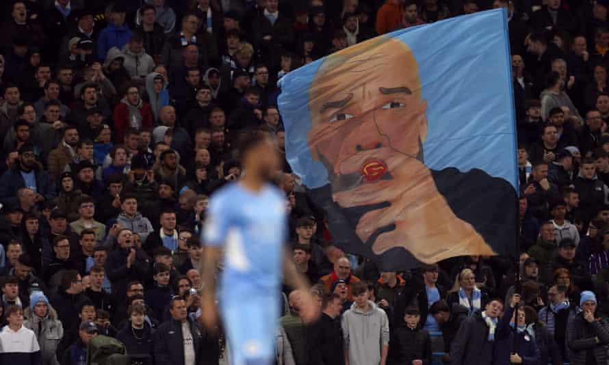 Aficionados del Manchester City exhiben una bandera del técnico Pep Guardiola.