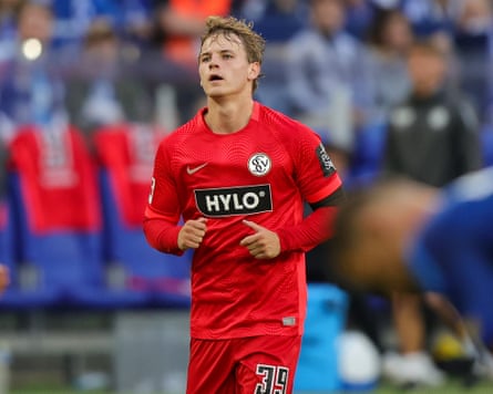 A young football player in a red kit.