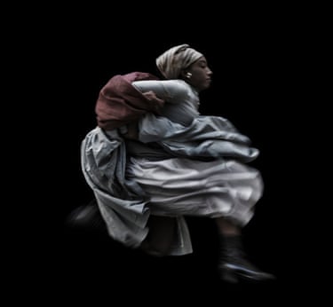 A woman running in a billowy, flowy dress against a black background.