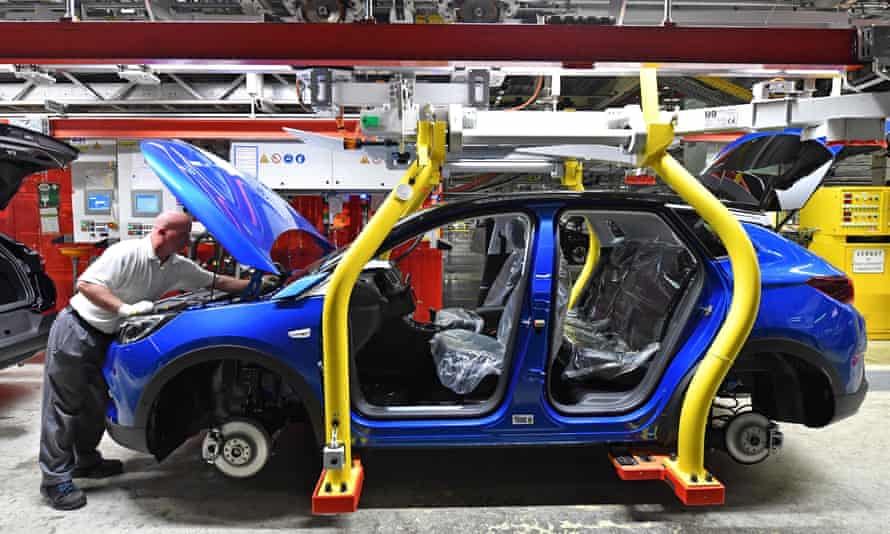 A man works on the assembling of an Opel Grandland X SUV car