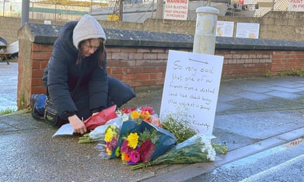 A local resident lays flowers at the entrance of Portland Port in Dorset on Tuesday after the death of an asylum seeker on board the Bibby Stockholm barge.