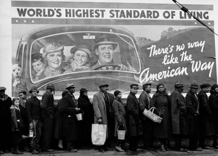 Flood victims in Louisville, Kentucky, US, February 1937, queueing to get food and clothing in front of a billboard sign that reads “WORLD’S HIGHEST STANDARD OF LIVING / THERE’S NO WAY LIKE THE AMERICAN WAY”