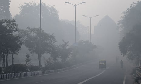 Indian commuters drive and cycle through air pollution in Delhi the day after Diwali.