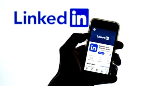 A smartphone held in front of a LinkedIn logo