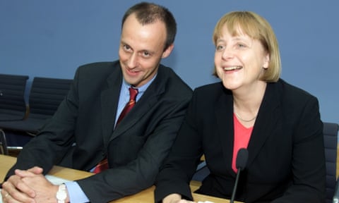 Friedrich Merz sits beside Angela Merkel at a table in 2001.