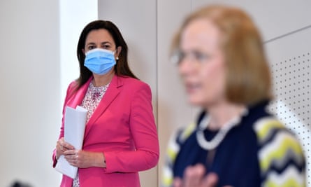 Annastacia Palaszczuk wearing a mask looks on as Queensland Chief Health Officer, Dr Jeannette Young, addresses the media