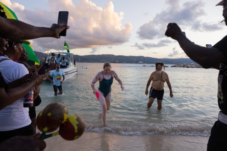Eva Buzo wades out of the sea towards a cheering crowd after her swim