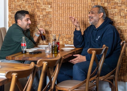 Two men facing each other across a restaurant table