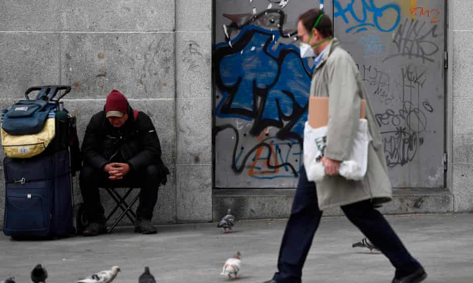 Man wearing  face mask walks down a high street in Spain