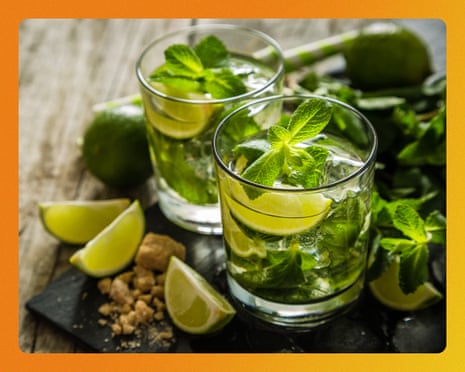 Mojito cocktails with fresh mint and lime on rustic wooden background