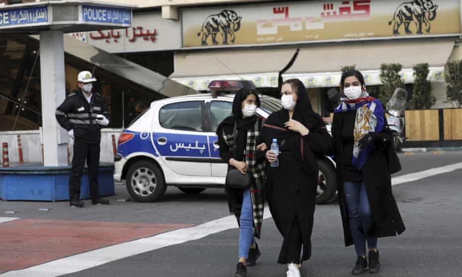 A police officer and pedestrians wear masks in central Tehran on Sunday
