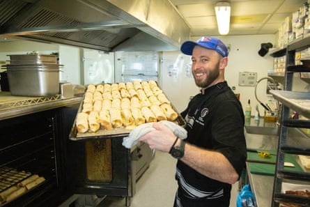 Chef holding tray of cheese rolls