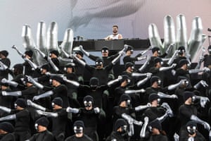 An array of masked dancers in front of the performer