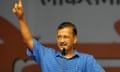 Arvind Kejriwal speaks into a microphone, holding one finger in the air.