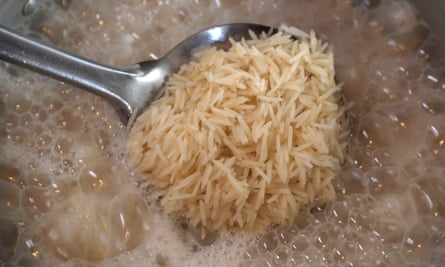 Basmati rice being spooned out of a pot of boiling water