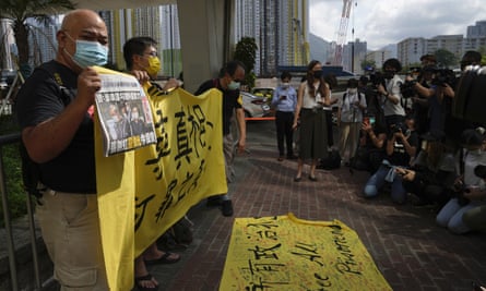 Pro-democracy activists holding a copy of Apple Daily newspaper and banner protest outside court in Hong Kong on Saturday.