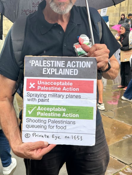 close-up of man holding sign saying ‘palestine action’ explained