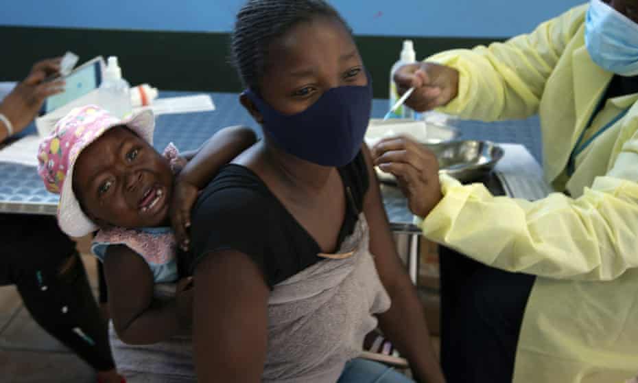 A mother receives her Pfizer vaccine against in Diepsloot Township near Johannesburg, South Africa.