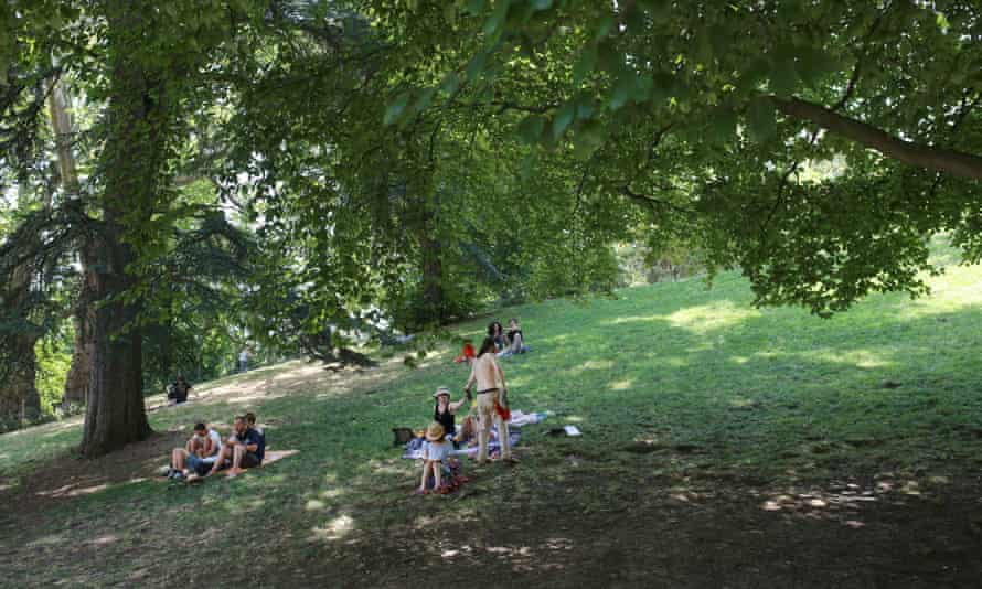 Families find respite from the harsh sun on the hottest day in Paris at Parc de Buttes-Chaumont