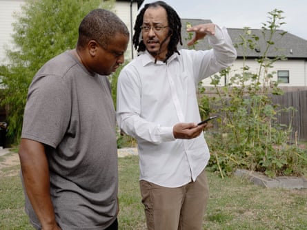 Abel Thompson shows Kai Freeman the smartphone app that tracks the solar panels input and output. Broadmoor Community Church in New Orleans, La October 21, 2023