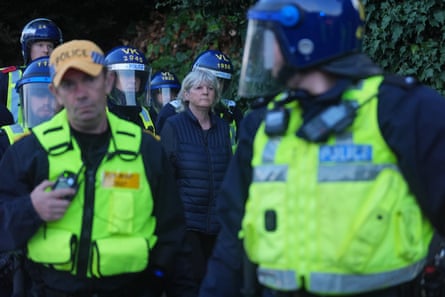 Police officers escort a woman away