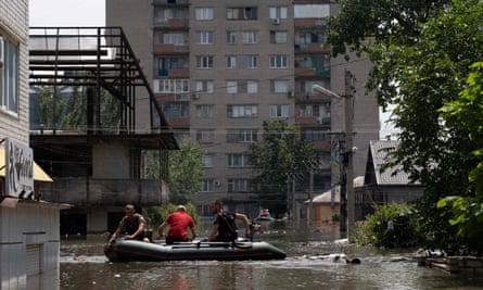 Forças de segurança ucranianas em um barco durante uma evacuação de uma área inundada em Kherson