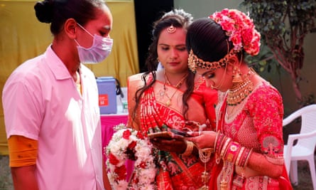 A bride searches for her coronavirus vaccination certificate to show it to a healthcare worker at her wedding venue.